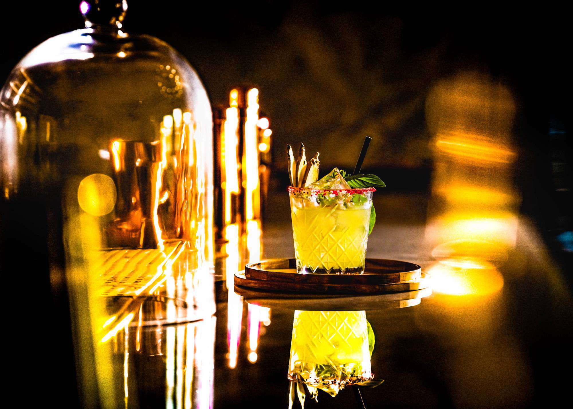 Cocktail in cut glass sits on dark bar at Winslade Manor Restaurant & Bar